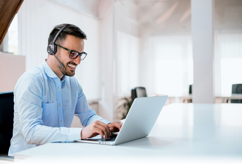 Choosing the best office headset for your business: man wearing headset and working on computer