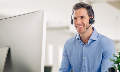 Best dual ear headsets: man wearing dual ear headset while working on computer
