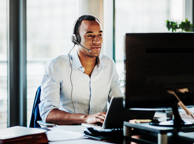 Best single-ear headsets: man wearing mono headset working at computer