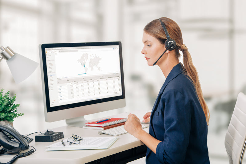 Woman wearing the best headset for desk phone at her computer